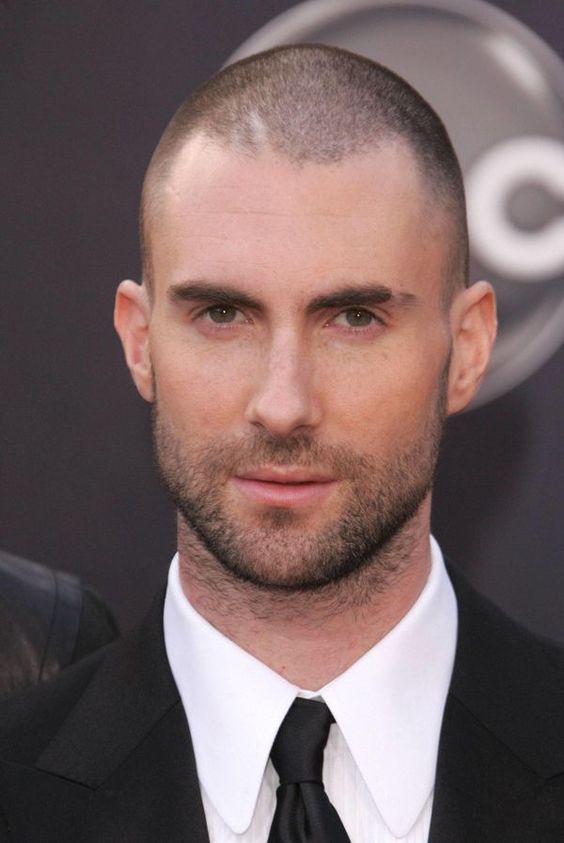 Adam Levine with a balding buzz cut hairstyle.