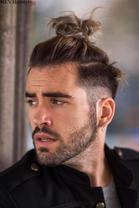 Man with top know hairstyle looking to left